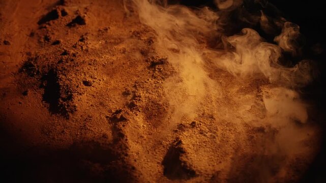 Dramatic abstract background showing an unknown planet's surface, possibly mars, with an orange sandy terrain and mysterious white vapor flowing over it against a dark, shadowy backdrop