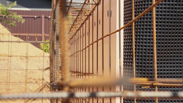 Rusty steel rebar cage prepared for pouring concrete into a formwork structure on a building site, showing the reinforcing metal bars for a strong monolithic foundation