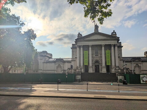 The neoclassical facade of Tate Britain art gallery on Millbank in London under a sunny sky