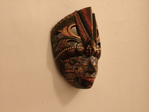 Angled view of a hand carved Indonesian wall mask