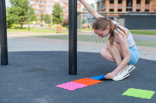 A woman with cerebral palsy walks on sensory mats. Rehabilitation
