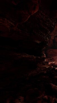 Light shines into a cave filled with dark rocks and stones. The sunlight creates bright patches on the ground. Shadows loom across the walls of the cave with vivid contrasts.