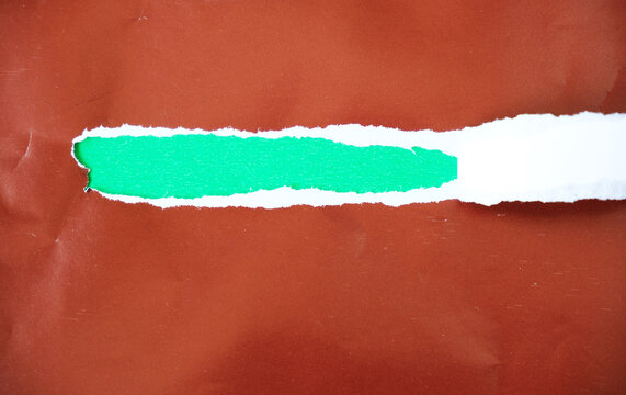 Torn paper with space for text on a green background. The brown torn paper peels away to reveal the green paper underneath.