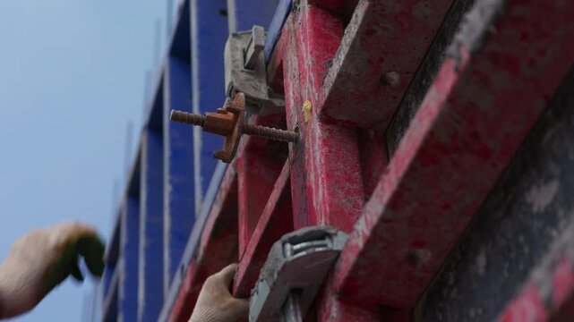 Installing formwork tie rod on concrete wall formwork close up