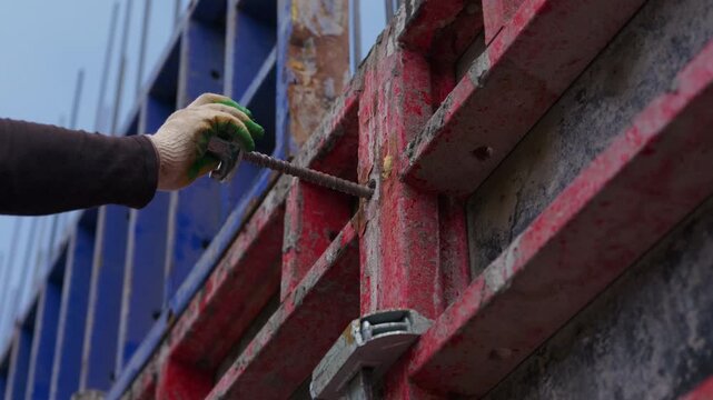 Installing formwork tie rod through wall formwork panel close up