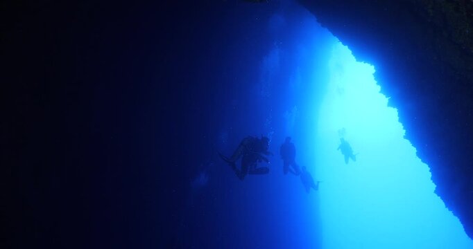 cave diving underwater scuba divers exploring caves and having fun ocean scenery sun beams and rays background