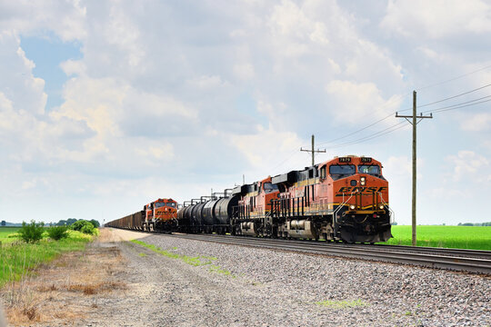 Two eastbound Burlington Northern Santa Fe freight trains meet in north central Illinois. At. left, a paused loaded coal train awaits a new crew while being passed by another coal drag.