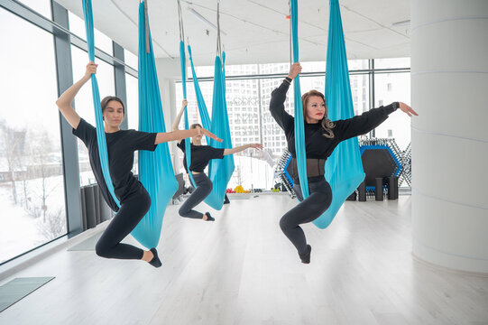 Group yoga class on hammocks. 