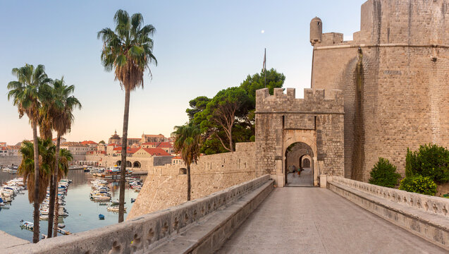 Historic Pile Gate, medieval city walls and marina in Dubrovnik Old Town, Croatia, during early morning light.