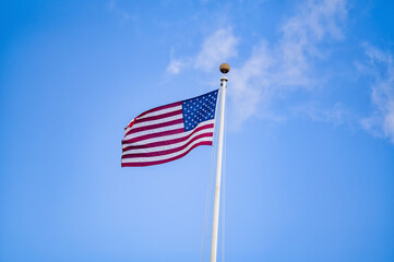 Obraz premium American Flag in Wind with Blue Sky.