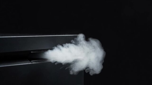 Cinematic macro smoke vapor fog mist steam emission from electronic device machine vent slot surface texture background with mysterious rising smoke vapor flow dark black backdrop creating dramatic