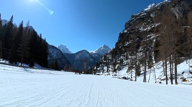 Point of view skiing downhill on snowy mountain slopes in winter