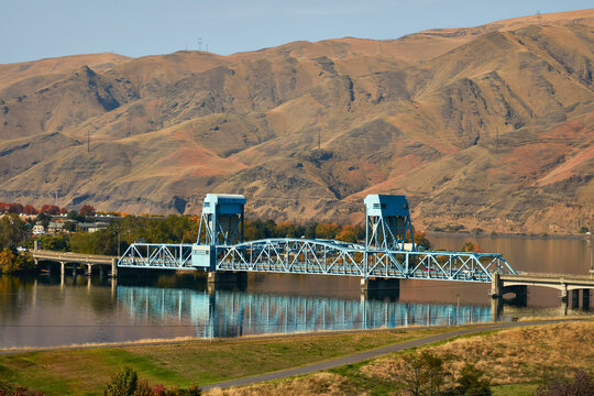 Arid mountain landscape with blue steel lift bridge over river