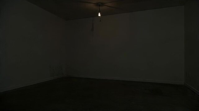 Empty room with flickering light bulb. Dark interior scene with dim illumination. Mysterious abandoned space with glowing electric lamp for suspenseful mood setting