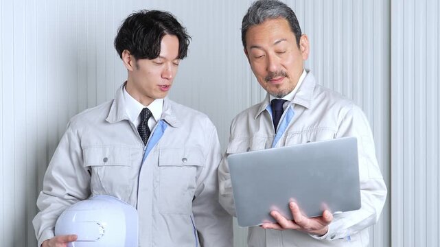 パソコンを使って現地調査をする作業員