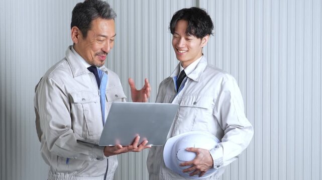 パソコンを使って現地調査をする作業員
