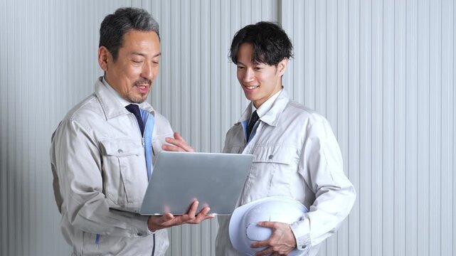 パソコンを使って現地調査をする作業員