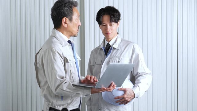 パソコンを使って現地調査をする作業員
