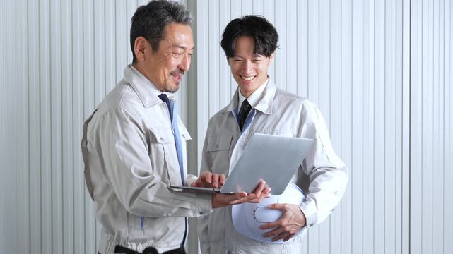 パソコンを使って現地調査をする作業員
