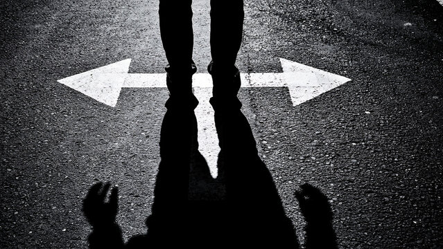 Person standing at a crossroads choosing between two directions with crossroads decision direction uncertainty standing opportunity strategy challenge motivation reflection destination
