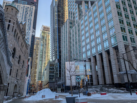 Canada, Montreal, 24 December 2025 : Tall buildings surround snowy urban street, creating modern architectural contrast.