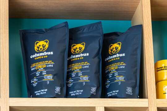 MONTREAL, CANADA, 24 December 2025 : Coffee bags display, Columbus Cafe packaging, wooden shelf, product branding, cafe interior