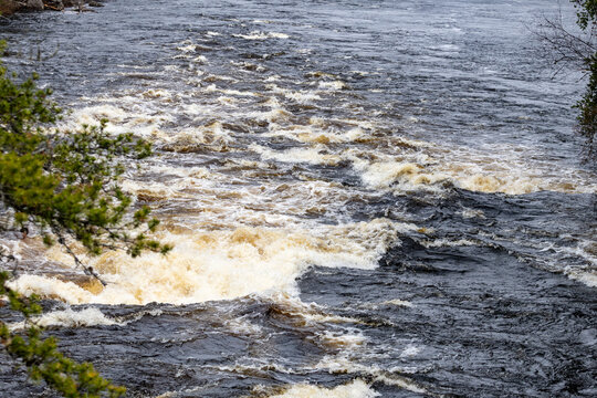 Parents, Quebec, 20 May 2026 : Turbulent river water flows with strong currents and white foam in a natural environment.