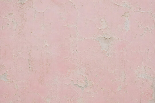 Vintage distressed pink plaster wall texture. Old crumbled stone surface with peeling paint. Shabby chic background.