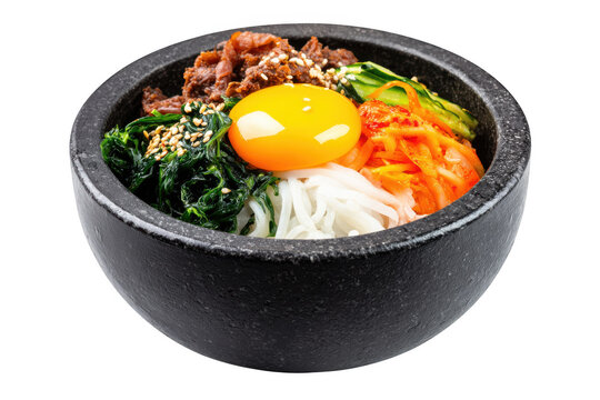 Delicious Korean stone bowl filled with rice noodles spinach sesame seeds and runny yolk