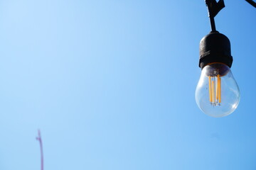 Hanging Vintage Edison Light Bulbs Against Blue Sky © Aisyah Faiha