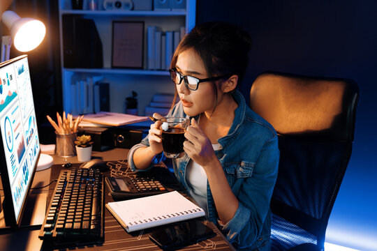 Creating young beautiful Asian creative woman thinking of sales target report on business market graph folder paperwork report, looking out of indoor with holding pen at neon at night time. Stratagem.