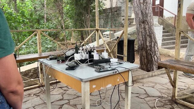 Community Charging Station During Power Outage: People Bringing Mobile Phones for Emergency Support
