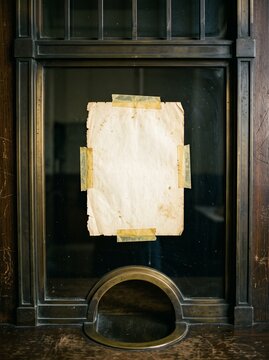 Old paper note taped to a vintage window with brass details