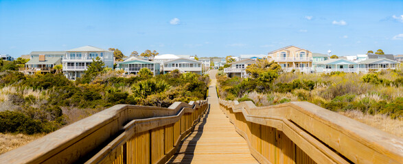 Fototapeta premium Wooden boardwalk leads to beach houses in South Carolina