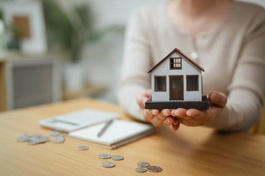 home ownership, house model, and property savings shape this practical household finance scene. It conveys practical choices, organized planning, everyday money management, and financial awareness.