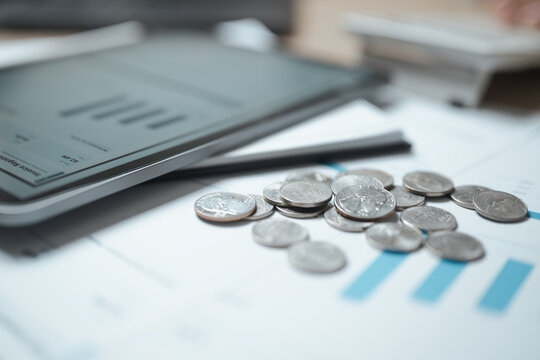 investment analysis, coin stacks, and financial chart shape this practical household finance scene. The composition communicates financial awareness, thoughtful choices, and household organization.