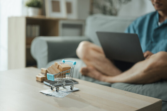 This focused image brings together online shopping, shopping budget, and miniature shopping cart. It conveys practical choices, organized planning, everyday money management, and financial awareness.