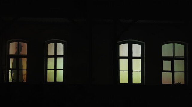Mysterious Shadows of People Behind Windows at Night. A man and a woman in 19th century clothes