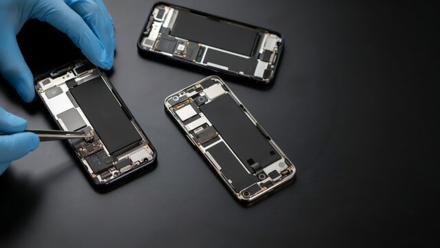 Technician repairing disassembled smartphones in a workshop