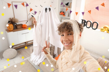 Obraz premium Boy and ghost costume taking Halloween selfie indoors