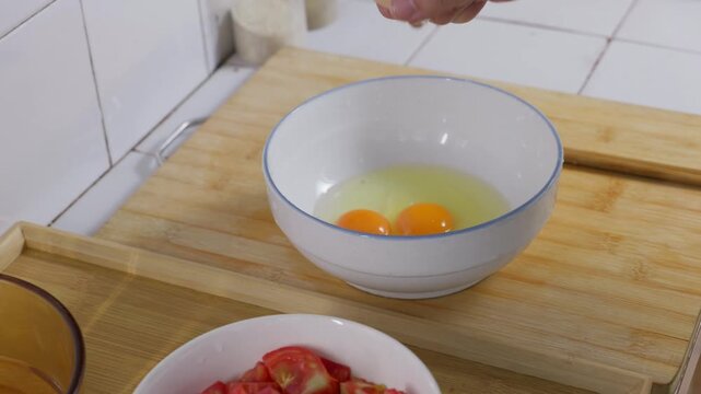 Three eggs are cracked into a bowl. Preparation before scrambled eggs. Cracked raw eggs.