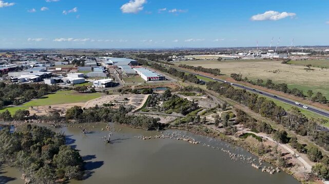 Aerial view of  Botanic Garden in Melton Melbourne, Australia.&nbsp;The landscape transitions into an industrial park with warehouses and commercial units, bordered by the busy Western Freeway.