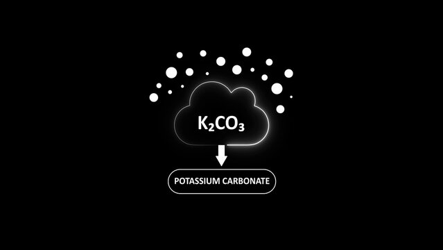 Potassium carbonate chemical formula k2 co3, represented as a glowing cloud with particles on a solid black background
