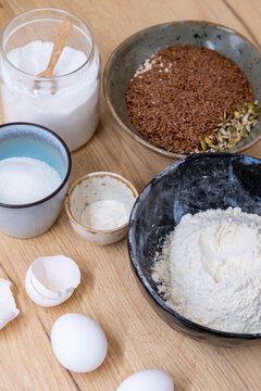 Homemade recipe. Baking pastry. Measured sugar salt flour flax seeds ingredient prepared in bowls for mixing dough on kitchen table background.