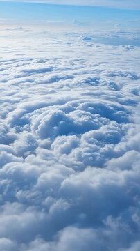 Aerial view of dense, textured cloud formations with a prominent circular swirl above the cloud layer