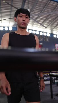 Asian man running on a treadmill at the gym. Young Asian man working out on a treadmill. Intense cardio training session for building endurance, improving health, and losing weight.