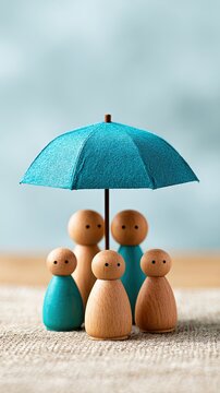 Wooden peg dolls, representing a family, stand together under a blue umbrella symbolizing protection and care.