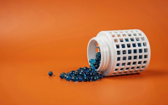 Blue gel capsules spilling out of a white plastic bottle