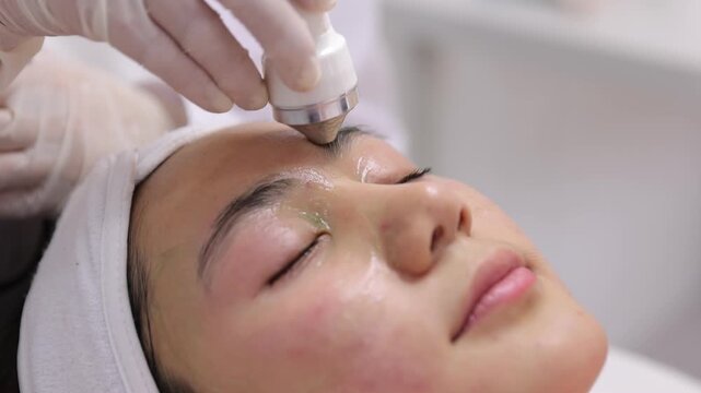 Asian woman receiving facial skincare rejuvenation treatment.