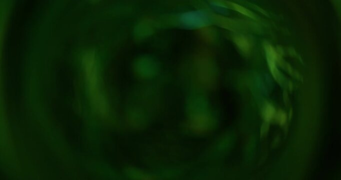 Bokeh light. Green glitter texture. Vibrant natural color lens flare bright optical glisten reflection on abstract illuminated black background.